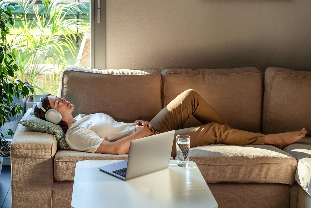 Woman relaxing on sofa during online counselling